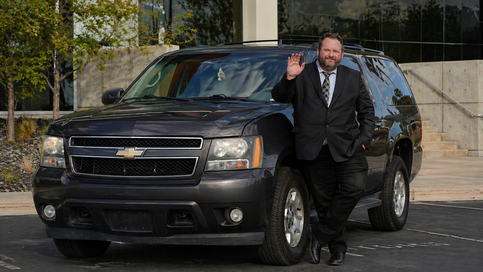 Adam Peeples waving beside the private long-distance SUV